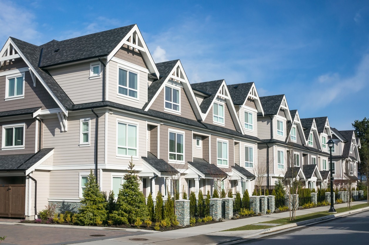  A row of contemporary townhomes on a street.